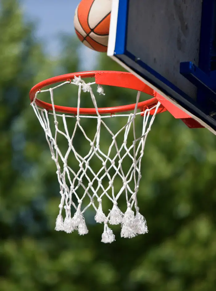 Outdoor basketball hoop with basketball going in the net