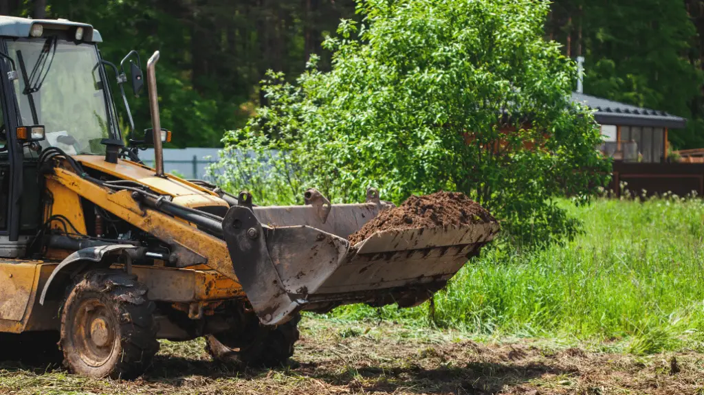 Excavator leveling a yard