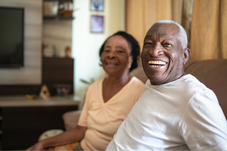 Senior couple sitting in their living room and smiling
